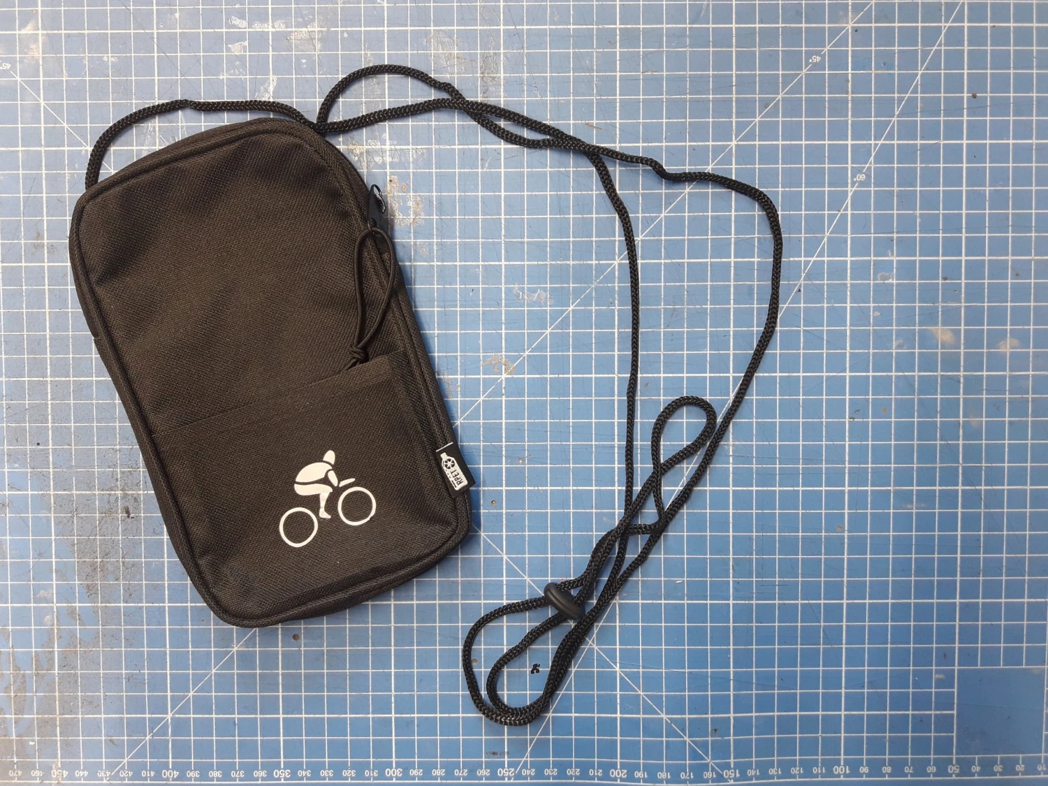 Pochette noire floquée avec l'image d'un cycliste stylisé (en blanc)
